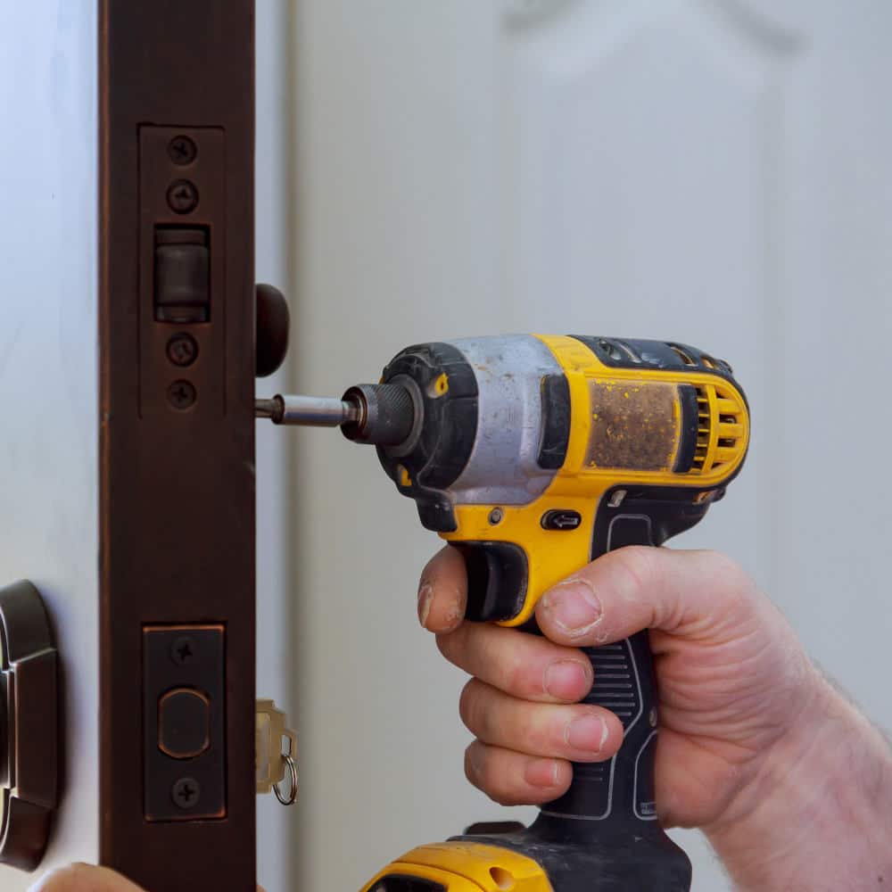 a locksmith for houses works on a door lock